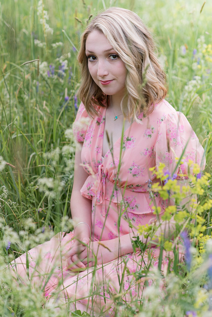 Ct high school senior girl sitting in field of wildflowers