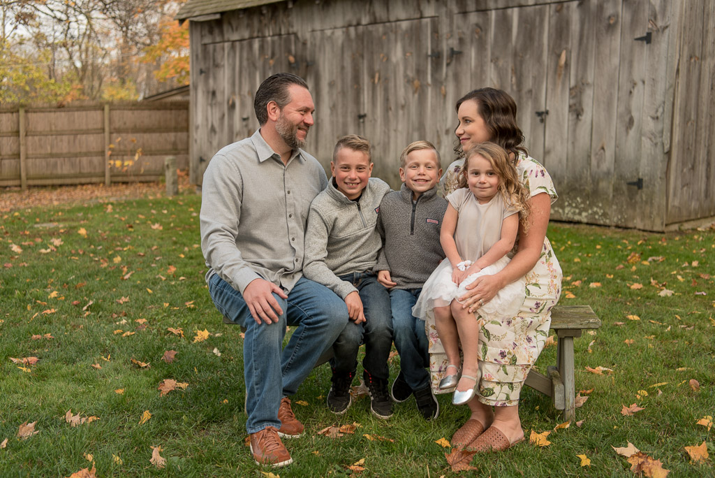 Family of five sitting on bench in front of barn| Sharon Leger Photography