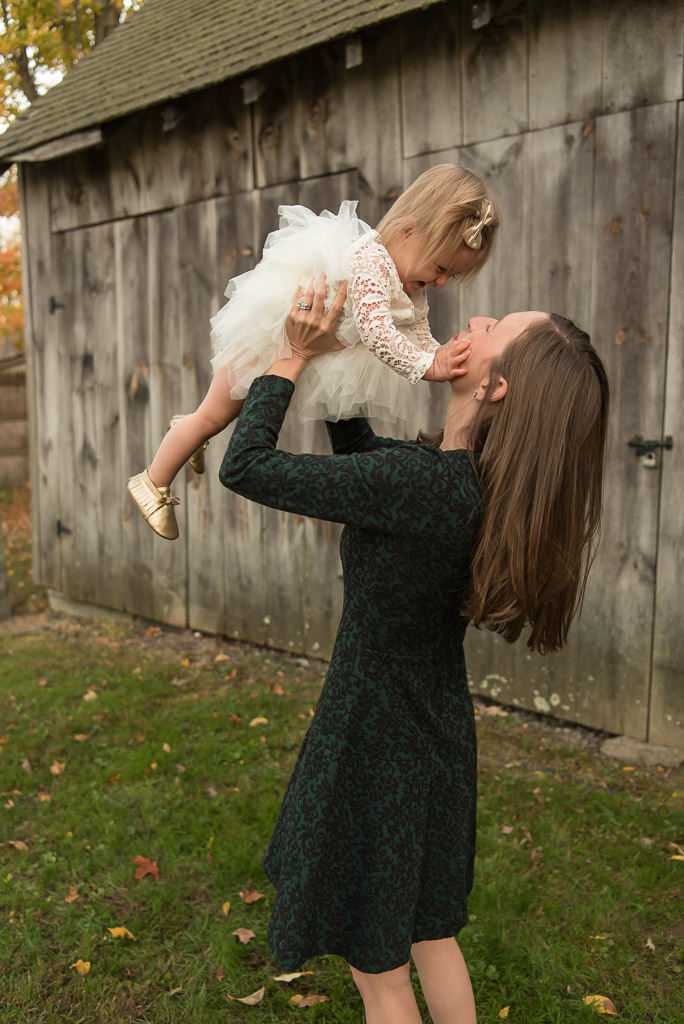 Mom in green dress playing with baby girl in white dress | Sharon Leger Photography