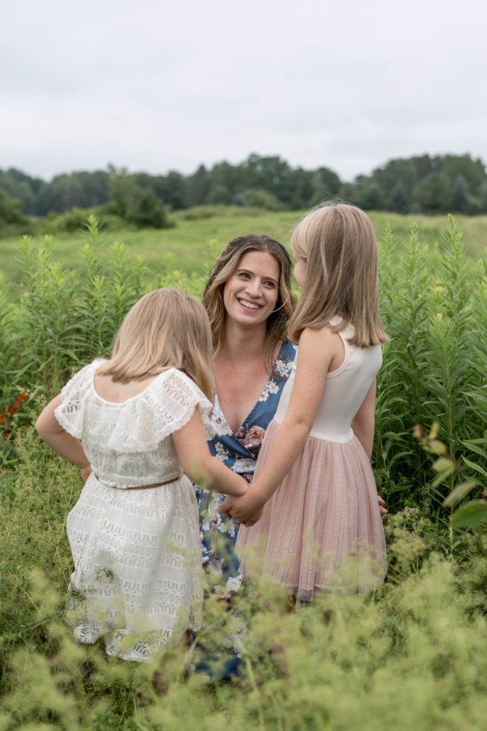 Mother talking to daughters in field in CT