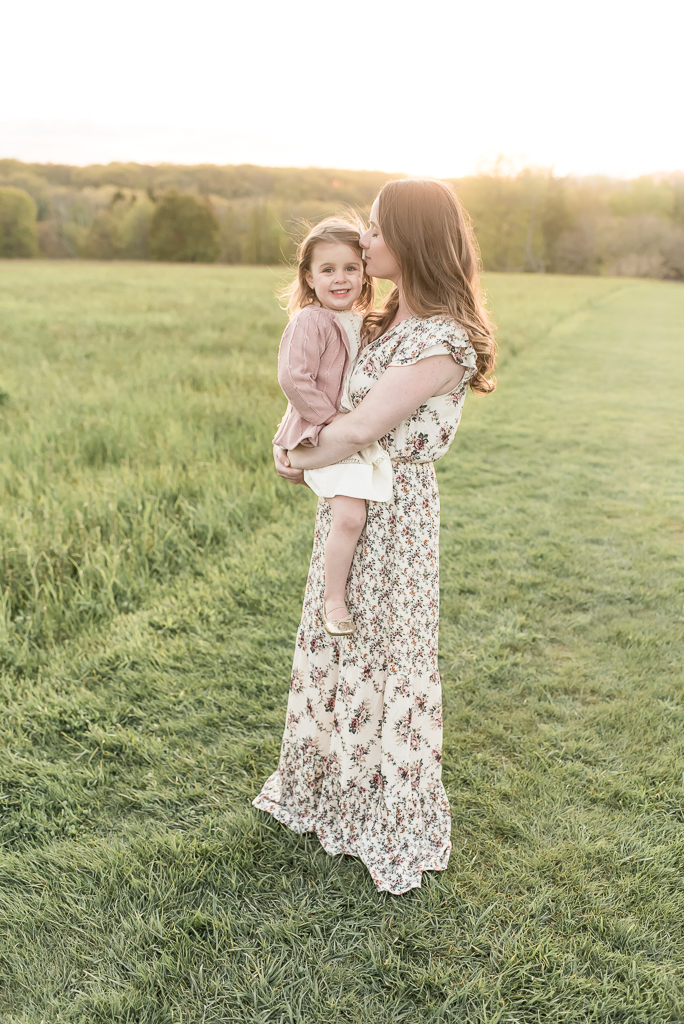 Mom and daughter in field at sunset