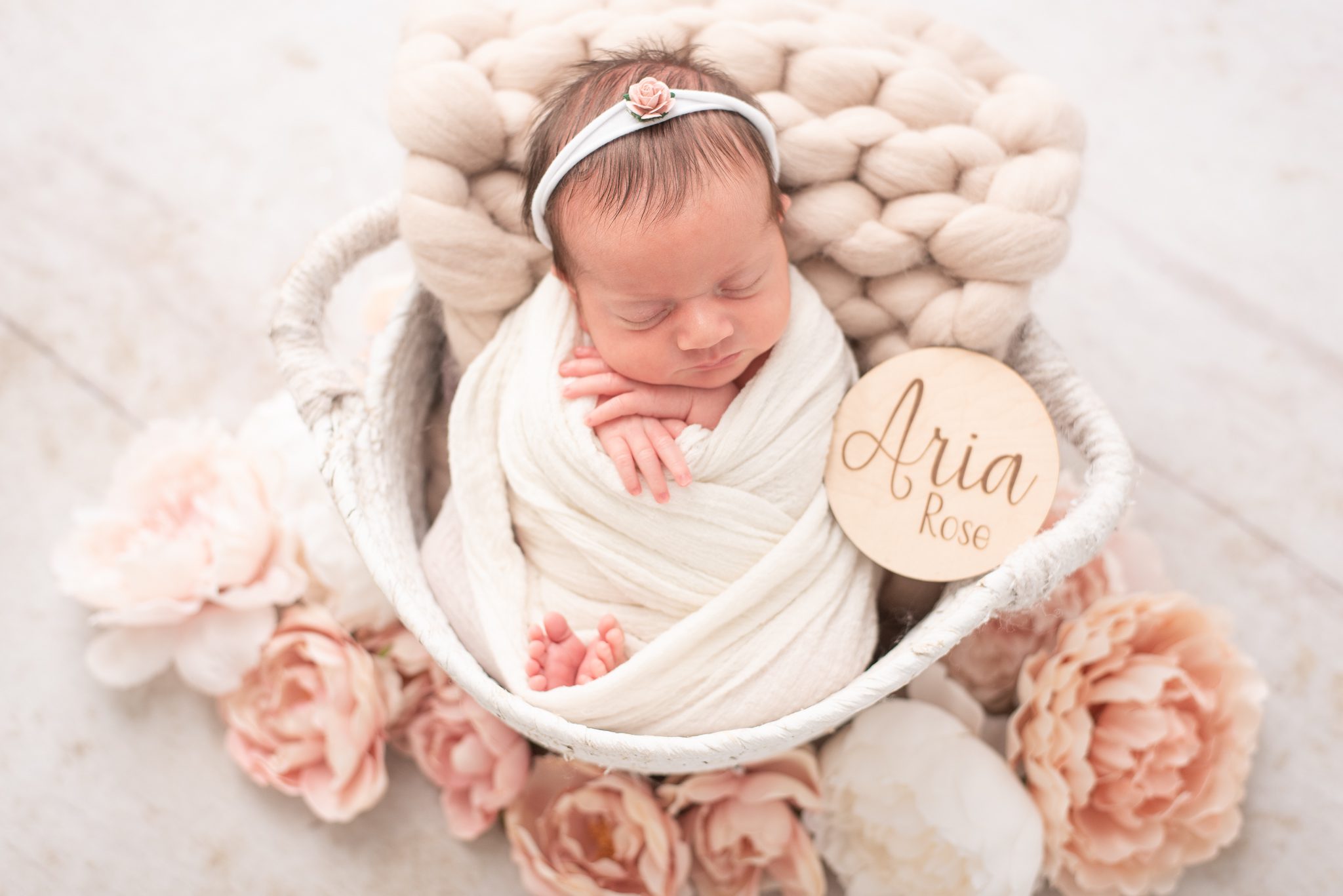 Close up of baby girl surrounded by flowers at her spring newborn session