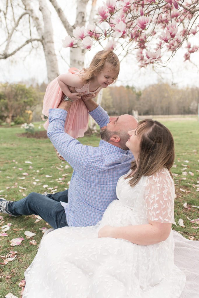 Father lifting his daughter up in the air by the blossoms at their Connecticut mini session